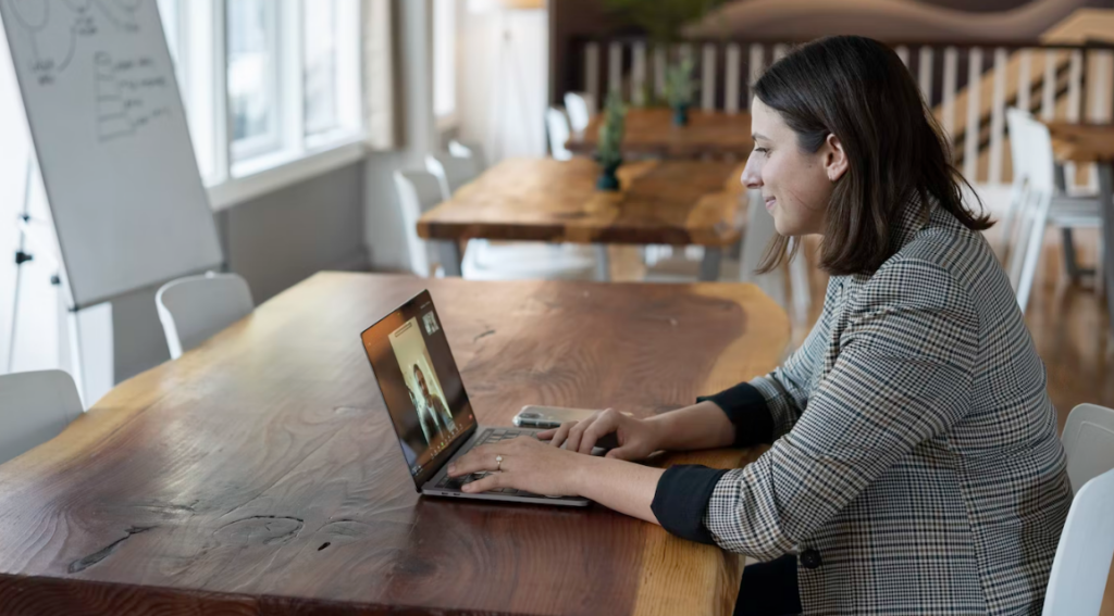 Vrouw volgt een online bijeenkomst achter laptop